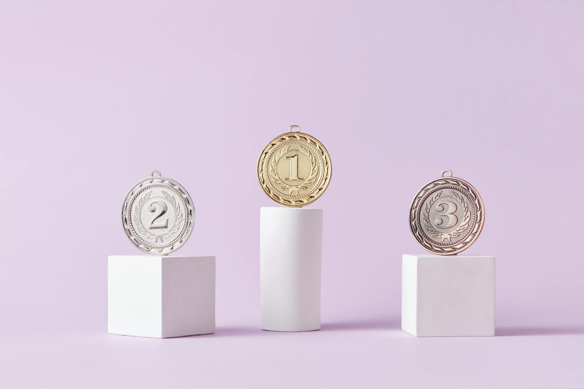 medals on pedestal on pink studio background