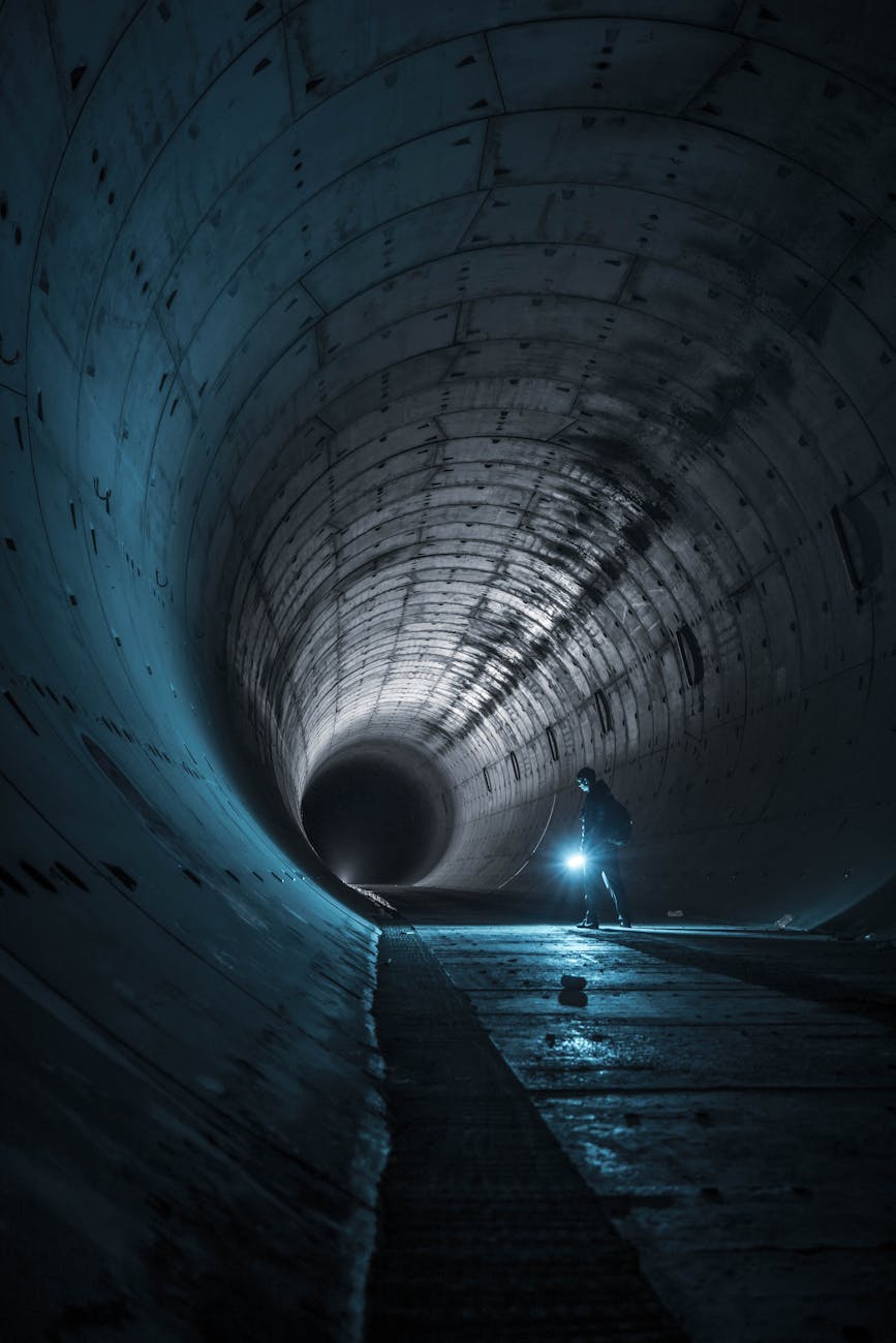 a man walking through a tunnel at night